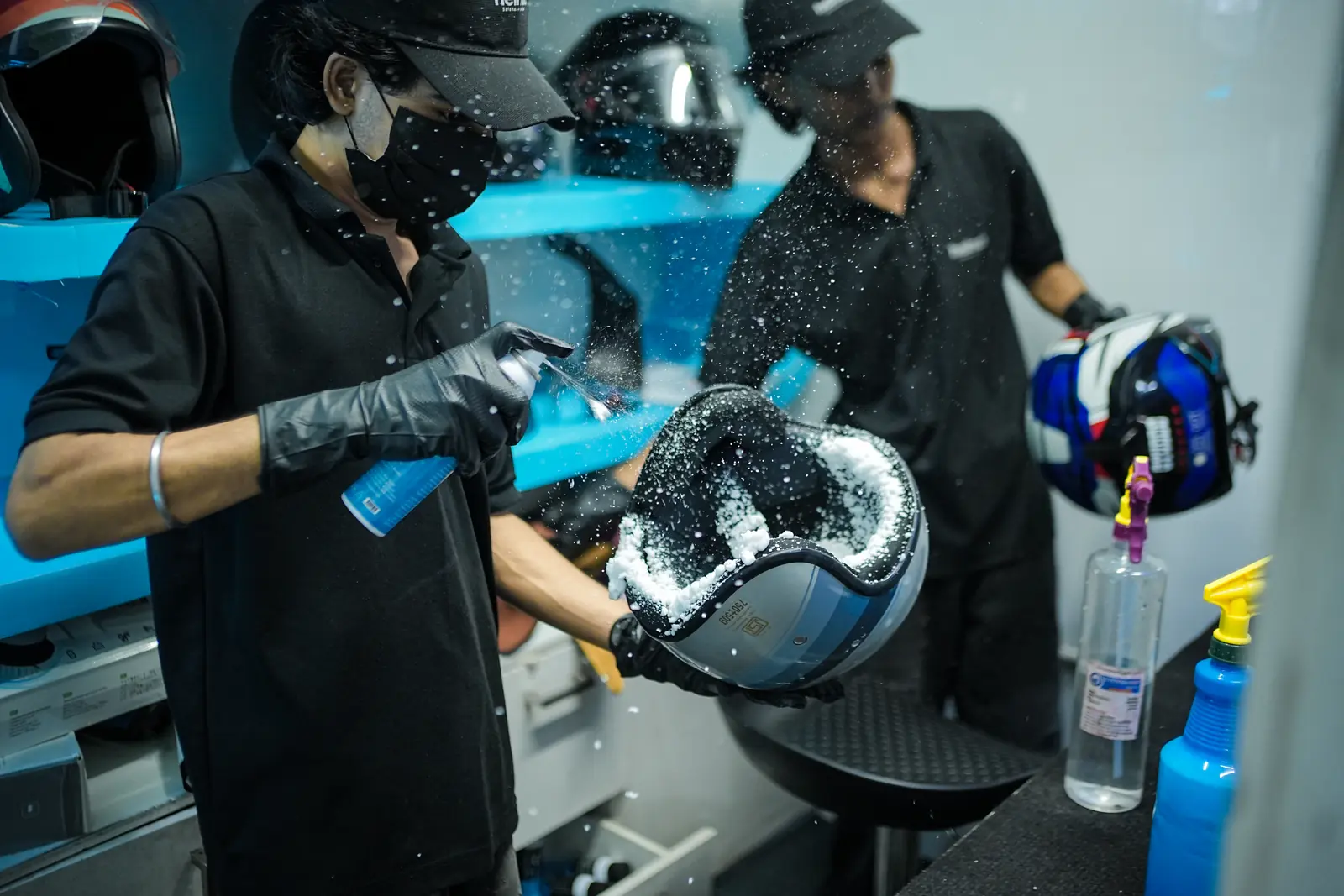Cleaning foam being sprayed across a disassembled helmet shell