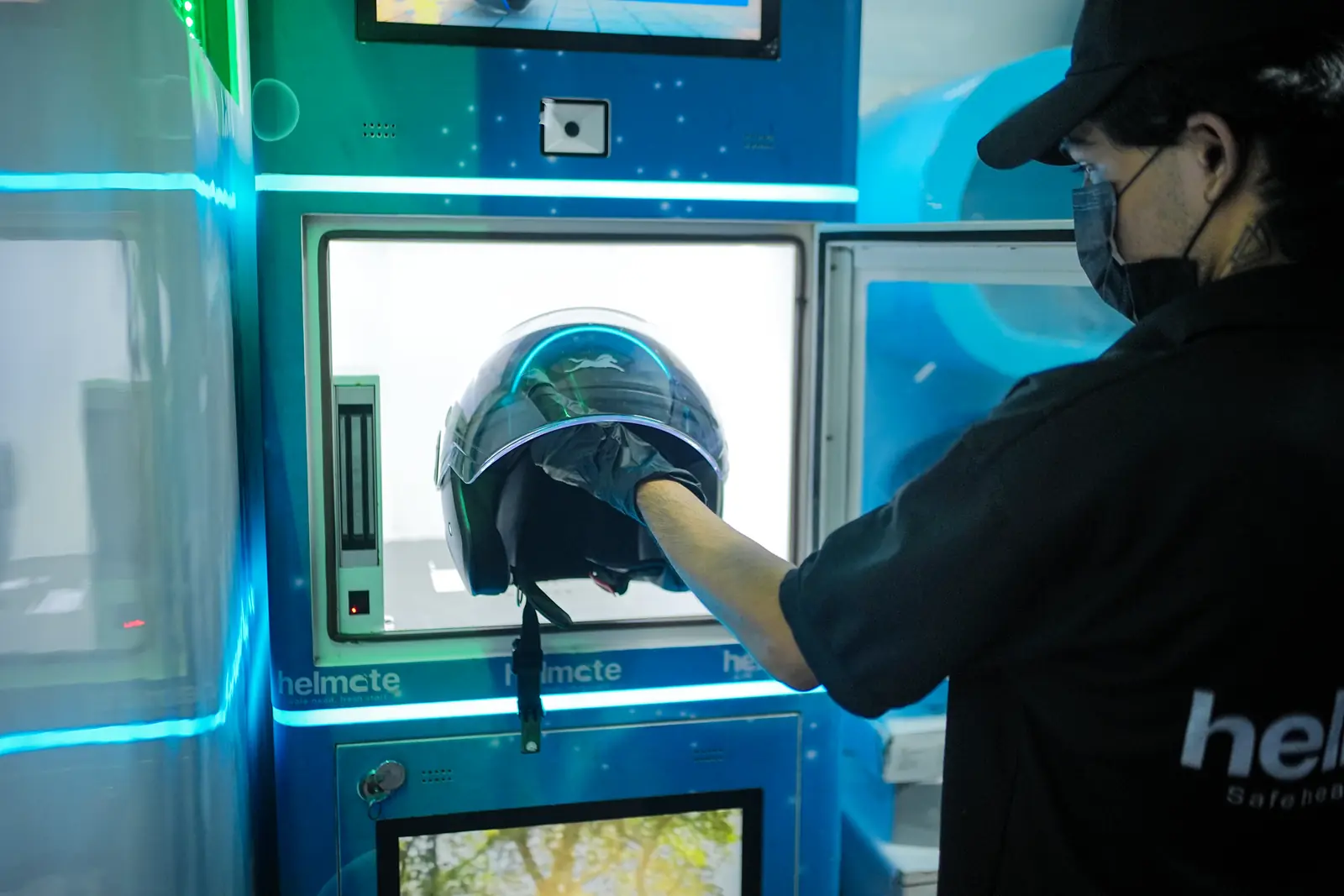A technician loading a helmet into the Helmate sterilization chamber
